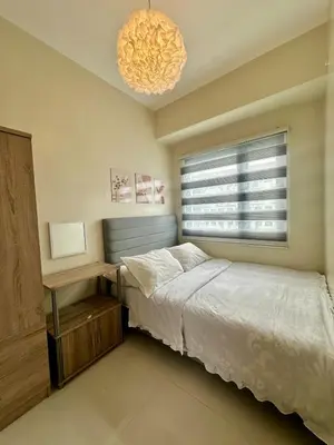 a bedroom with a bed and a window at Mall of Asia Staycation with fast wifi and google tv in Manila