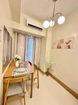 a dining room with a wooden table and chairs at Mall of Asia Staycation with fast wifi and google tv in Manila