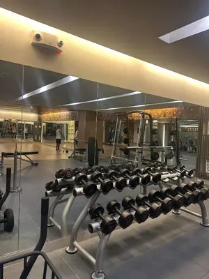 a gym with a rack of dumbbells and a mirror at Mall of Asia Staycation with fast wifi and google tv in Manila