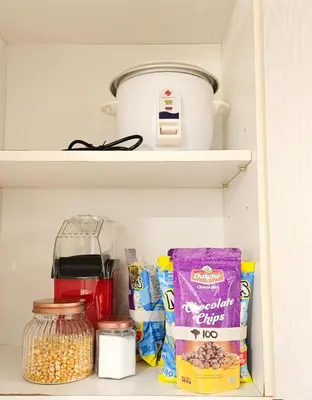 a pantry filled with food and a pot on a shelf at NEMM Staycation in Manila