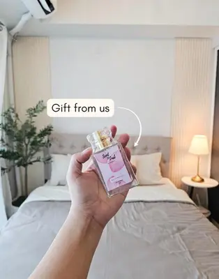 a person holding a gift from us in a bedroom at NEMM Staycation in Manila