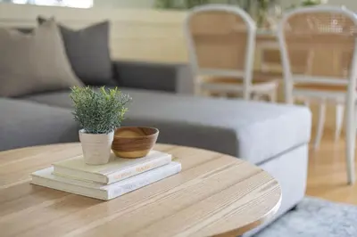 a coffee table with two potted plants on top of books at 2 BR Golf View Loft Timeless Charm in Avant BGC in Manila