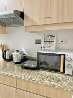 a microwave oven sitting on a counter in a kitchen at Staycation by Darvy in Manila