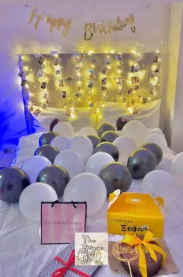 a bed with white and blue balloons and a happy birthday sign at Staycation by Darvy in Manila