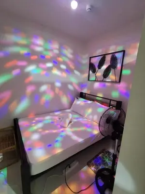 a bedroom with a bed with a multicolored bedspread at Aldo mall of Asia condotel in Manila