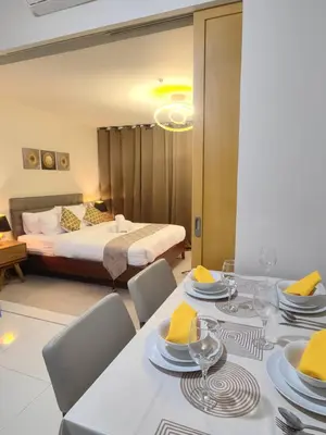 a room with a dining table and a bed at Uptown BGC Spacious 1BR Unit by Terravista - Prague Suite in Manila