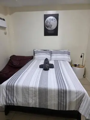 a teddy bear sitting on top of a bed at Pioneerwoodlands Mandaluyong Studio Unit in Manila