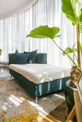 a bed sitting in a living room with plants at Glass House w Stunning View in Poblacion Makati in Manila