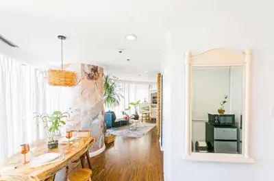 a living room with a table and a mirror at Glass House w Stunning View in Poblacion Makati in Manila