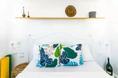 a bedroom with a bed with blue and white pillows at Glass House w Stunning View in Poblacion Makati in Manila
