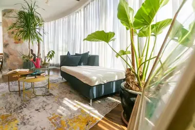 a living room with a bed and lots of plants at Glass House w Stunning View in Poblacion Makati in Manila