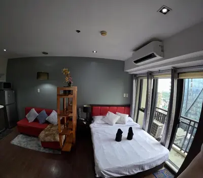 a bedroom with a bed and a red couch at 56th Floor -Sauna - Makati View - Knightsbridge Residences in Manila