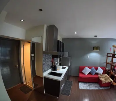 a kitchen and living room with a red couch at 56th Floor -Sauna - Makati View - Knightsbridge Residences in Manila