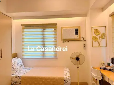 a bedroom with a bed and a desk and a window at La Casandrei in Dasmariñas