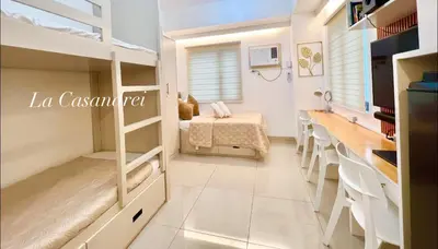 a room with two bunk beds and a table at La Casandrei in Dasmariñas