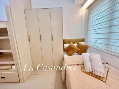 a bedroom with a bed with white cabinets and towels at La Casandrei in Dasmariñas