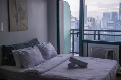 a bed in a room with a view of a city at C-Studio,Best Sunset Pool,Luxury,Hotel Style in Manila