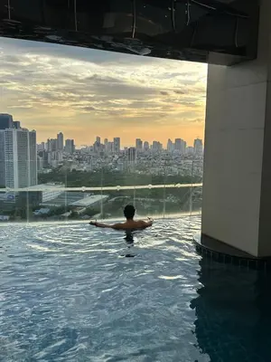 a man standing in the water in a swimming pool at D-Studio,Best Sunset Pool,Luxury,Hotel Style in Manila