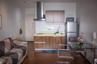 a kitchen with a couch and a table and a refrigerator at D-Studio,Best Sunset Pool,Luxury,Hotel Style in Manila