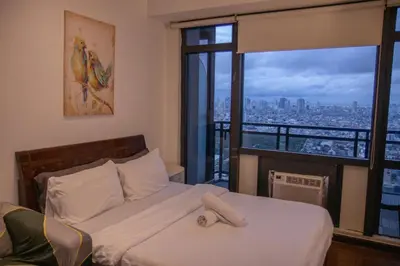 a bedroom with a bed with a view of a city at D-Studio,Best Sunset Pool,Luxury,Hotel Style in Manila