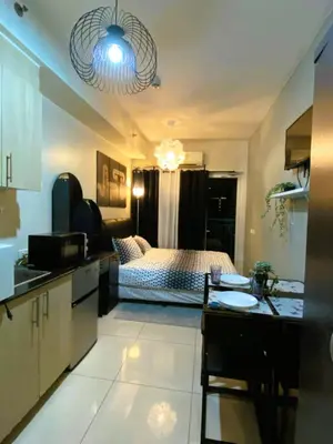 a kitchen and a bedroom with a bed and a table at Chateau Staycation in Manila