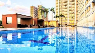 a large swimming pool in a city with tall buildings at Chateau Staycation in Manila