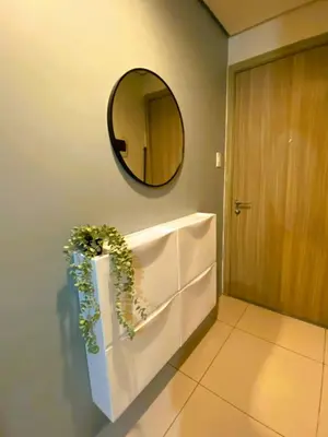 a bathroom with a mirror and a plant on the wall at Chateau Staycation in Manila