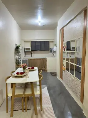 a living room with a table and a kitchen at Canlubang Transient house Asia 1 near 7-11 in Calamba