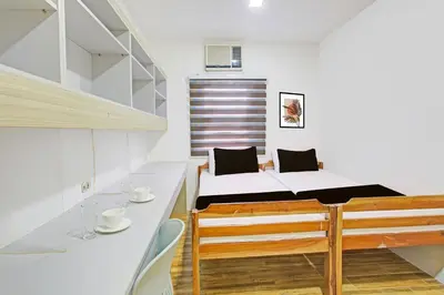 a small bedroom with a bed and a table and chairs at Belvilla College Residences In University Belt, Metro Manila in Manila