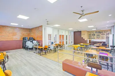 a dining area with tables and chairs in a restaurant at Belvilla College Residences In University Belt, Metro Manila in Manila