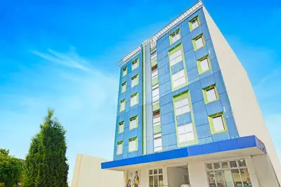 a blue and white building with a tree at Belvilla College Residences In University Belt, Metro Manila in Manila