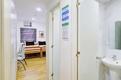 a bathroom with a sink and a desk in a room at Belvilla College Residences In University Belt, Metro Manila in Manila