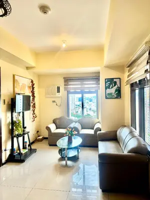 a living room with two couches and a table at LeMoon's Chill with beautiful view-1 Bedroom in Manila