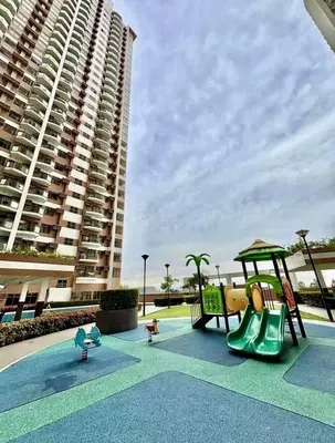 a playground in front of a large apartment building at LeMoon's Chill with beautiful view-1 Bedroom in Manila