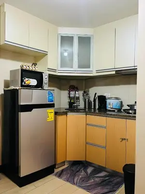a kitchen with a microwave on top of a refrigerator at Walking Distance Condo Across Naia T3 Airport in Manila