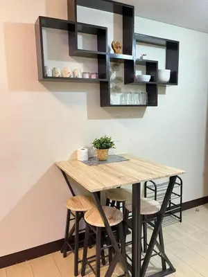 a dining room with a wooden table and stools at Walking Distance Condo Across Naia T3 Airport in Manila