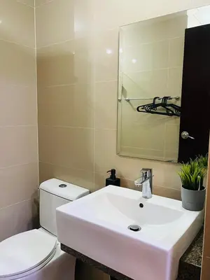 a bathroom with a white sink and a toilet at Walking Distance Condo Across Naia T3 Airport in Manila