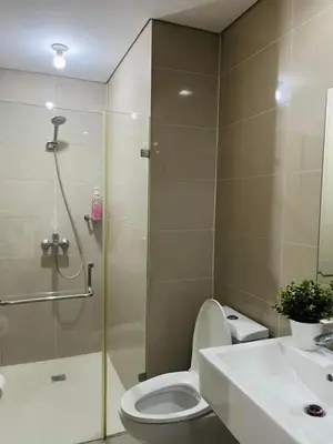 a bathroom with a shower and a toilet and a sink at Kyedenz Unit -Two Palm Tree Villas Newport Naia T3 in Manila