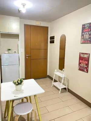 a small kitchen with a table and a refrigerator at 5min Staycation Away from Naia Terminal 3 Airport in Manila