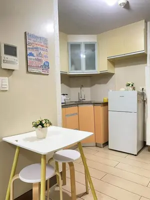 a kitchen with a table and chairs and a refrigerator at 5min Staycation Away from Naia Terminal 3 Airport in Manila