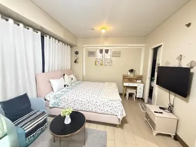 a bedroom with a bed and a couch and a tv at 5min Staycation Away from Naia Terminal 3 Airport in Manila