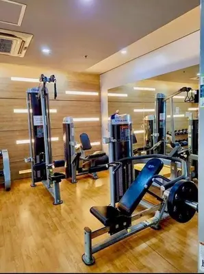 a gym with several tread machines in a room at Kyendenz Condotel-Across Naia T3 Pool View with Wifi in Manila