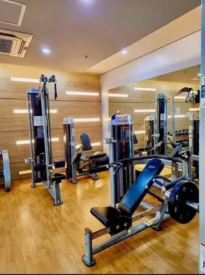 a gym with several tread machines in a room at Staycation Unit at Two Palm Across Naia T3 with WIFI in Manila