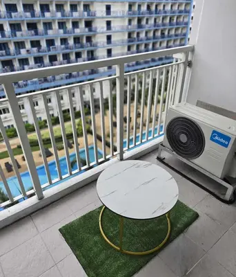 a table on a balcony with a table and a television at Staycation in Paranaque by Indigo in Manila