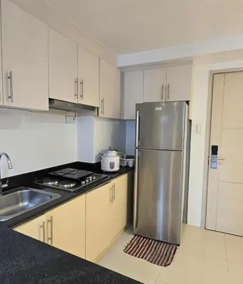 a kitchen with a stainless steel refrigerator and a sink at Staycation in Paranaque by Indigo in Manila