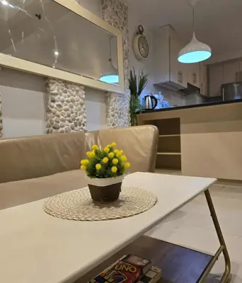 a table with a vase with yellow flowers on it at Staycation in Paranaque by Indigo in Manila