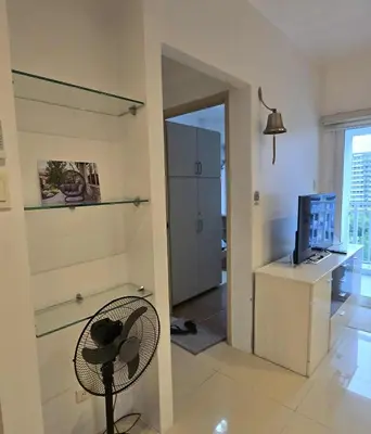 a living room with a chair and a television at Staycation in Paranaque by Indigo in Manila