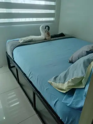 a bed with a stuffed animal sitting on it at Luxurious Condo in the Heart of Makati Philippines in Manila