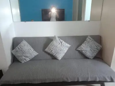 a person taking a picture of a couch with pillows at Luxurious Condo in the Heart of Makati Philippines in Manila