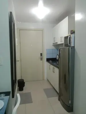 a small kitchen with a refrigerator and a door at Luxurious Condo in the Heart of Makati Philippines in Manila